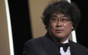 Director Bong Joon-ho accepts the Palme d'Or award for the film 'Parasite' during the awards ceremony at  Cannes, southern France, Saturday, May 25, 2019.