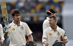 Australia's Joe Burns (L) celebrates his century as team-mate David Warner looks on during day three of the first Test cricket match between Australia and New Zealand in Brisbane on November 7, 2015. AFP PHOTO / Saeed KHAN