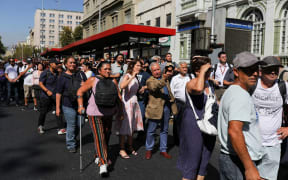 People stand outside buildings after a large power outage struck vast swaths of the country, in Santiago, Chile, on 25 February.  A massive blackout hit Chile on Tuesday including the capital Santiago and its surrounding area.