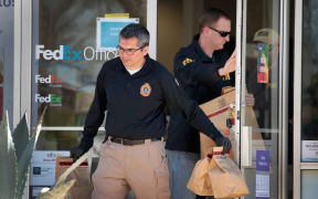 FBI agents collect evidence at a FedEx Office facility following an explosion at a nearby sorting center in Sunset Valley, Texas.