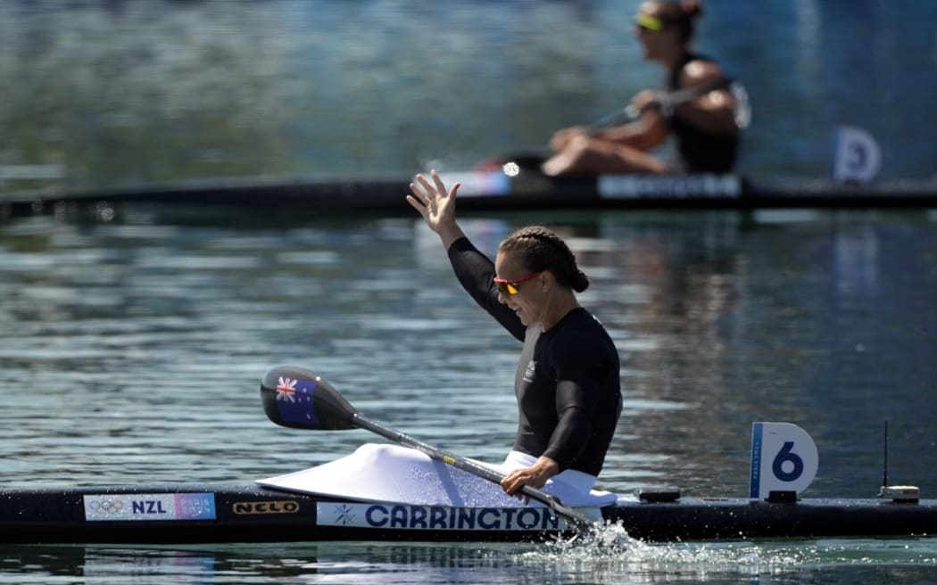 New Zealand's gold medallist Lisa Carrington celebrates after crossing the finish ahead of Hungary's Tamara Csipes (TOP) in the women's kayak single 500m final of the canoe sprint competition at Vaires-sur-Marne Nautical Stadium in Vaires-sur-Marne during the Paris 2024 Olympic Games on August 10, 2024. (Photo by Bertrand GUAY / AFP)