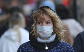 A woman in London wears a mask as a precaution against coronavirus.