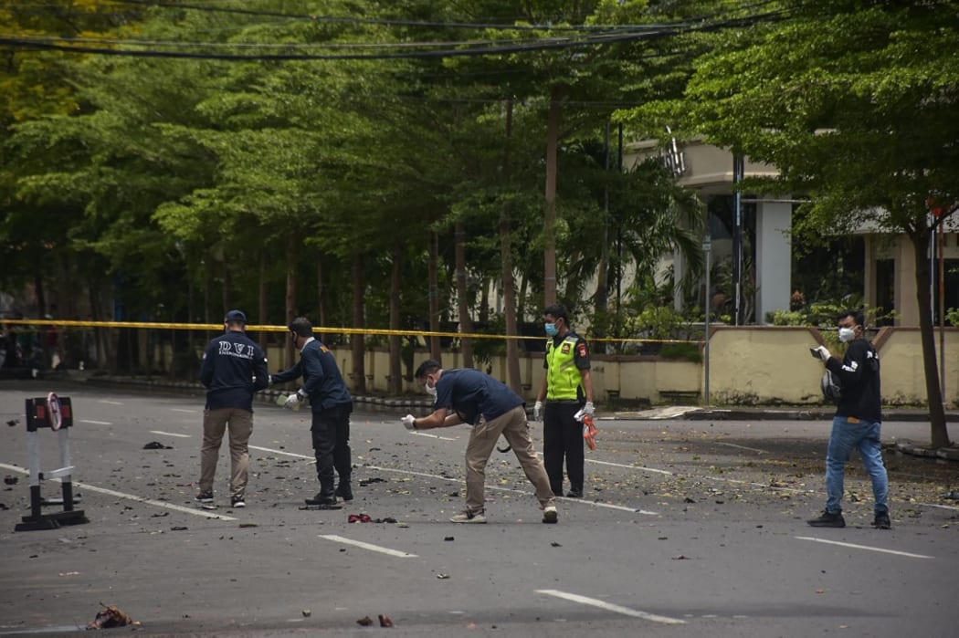 Indonesian forensic police examine the site after a suspected bomb exploded near a church in Makassar on March 28, 2021. (Photo by INDRA ABRIYANTO / AFP)