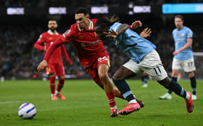 Liverpool's English defender Trent Alexander-Arnold, left, vies with Manchester City's Belgian midfielder Jeremy Doku during the English Premier League match at Etihad Stadium in Manchester, Feb 23, 2025.