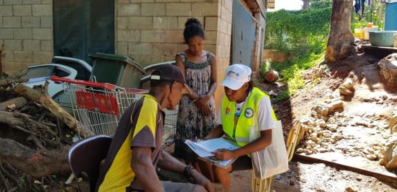 A Papua New Guinea census official helping people fill out census forms for the 2021 census, in 2020.