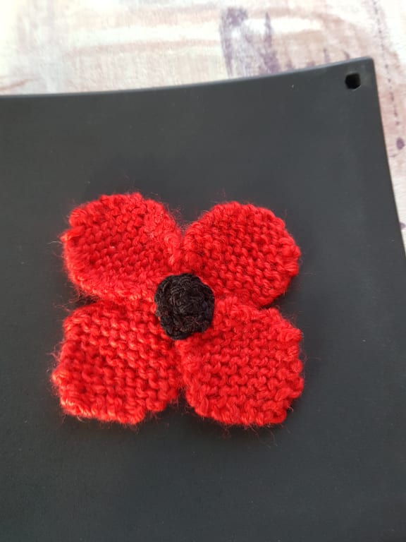 A knitted ANZAC poppy by John Santos' wife