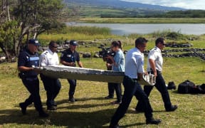 Police carry a piece of debris from an aircraft found in the coastal area of Saint-Andre de la Reunion, in the east of the French Indian Ocean island of La Reunion.
