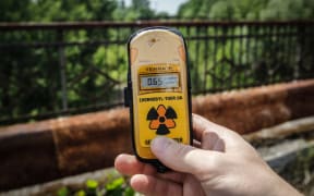 A visitor measures the level of radiation on the so-called Death bridge in the abandoned city of Pripyat, near the Chernobyl nuclear power plant, Ukraine, on 7 June 2019.