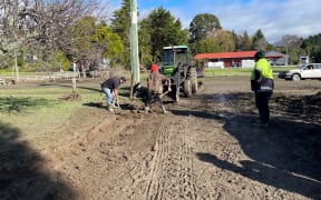 Workers start the clean-up after floods damaged roads and walkways in Tokomaru  Bay.