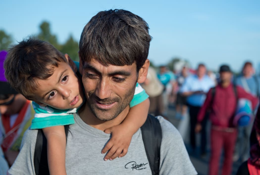 Hundreds of refugees from Syria, Iraq and Africa walk along the motorway towards the Austrian border.