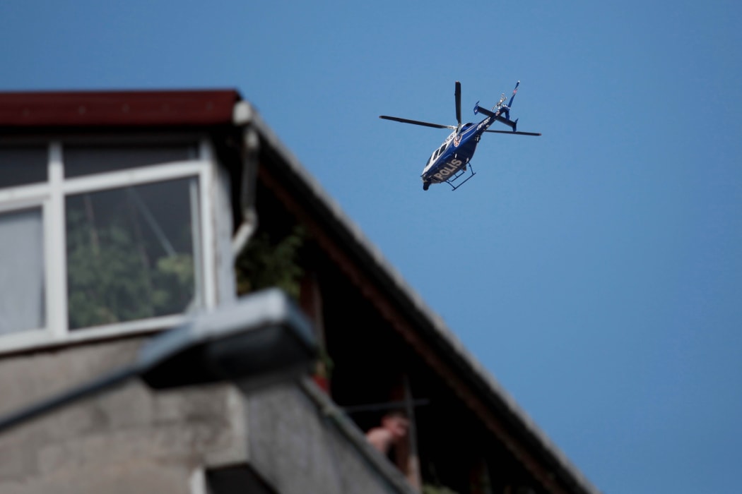 A police helicopter hovers during the funeral at Gazi Street in Istanbul for three of those killed in Suruc.