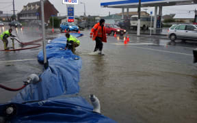 Emergency services pumping water out from flooded shops.