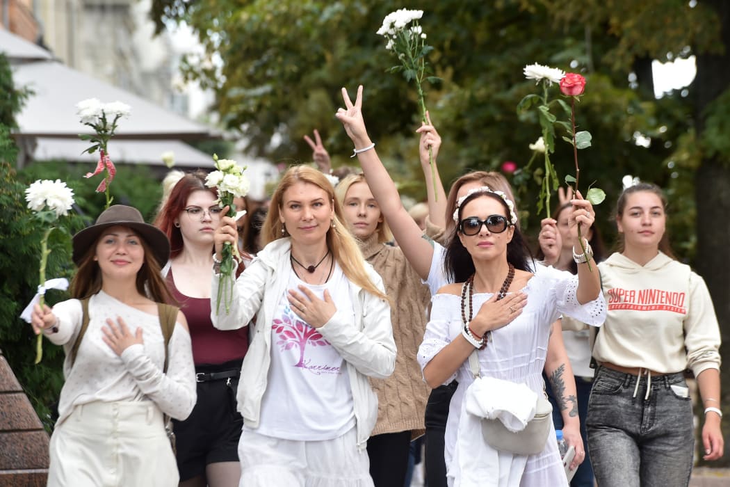 Women holding flowers protest against police violence during recent rallies of opposition supporters, who accuse strongman Alexander Lukashenko of falsifying the polls in the presidential election, in Minsk on August 13, 2020.