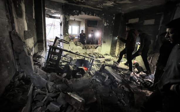 People inspect the wreckage of a building that was housing a group of militants and was hit by rockets during an Israeli army raid in the Jenin camp.