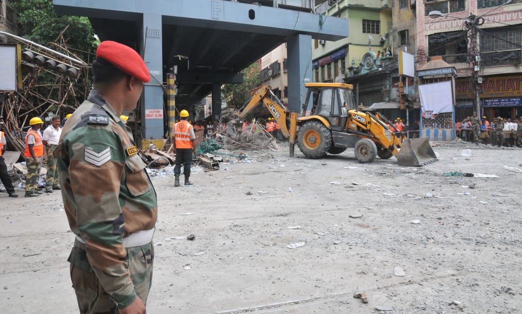 Indian rescue workers clear away debris to free people trapped under the collapsed flyover in Kolkata.