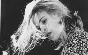 A black and white photograph of Jan Hellriegel playing at the Mountain Rock Festival in 1993.