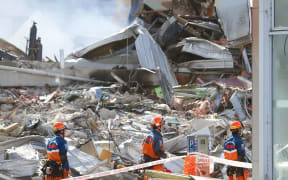 Japanese rescuers search the CTV building site two days after the 22 February 2011 earthquake.