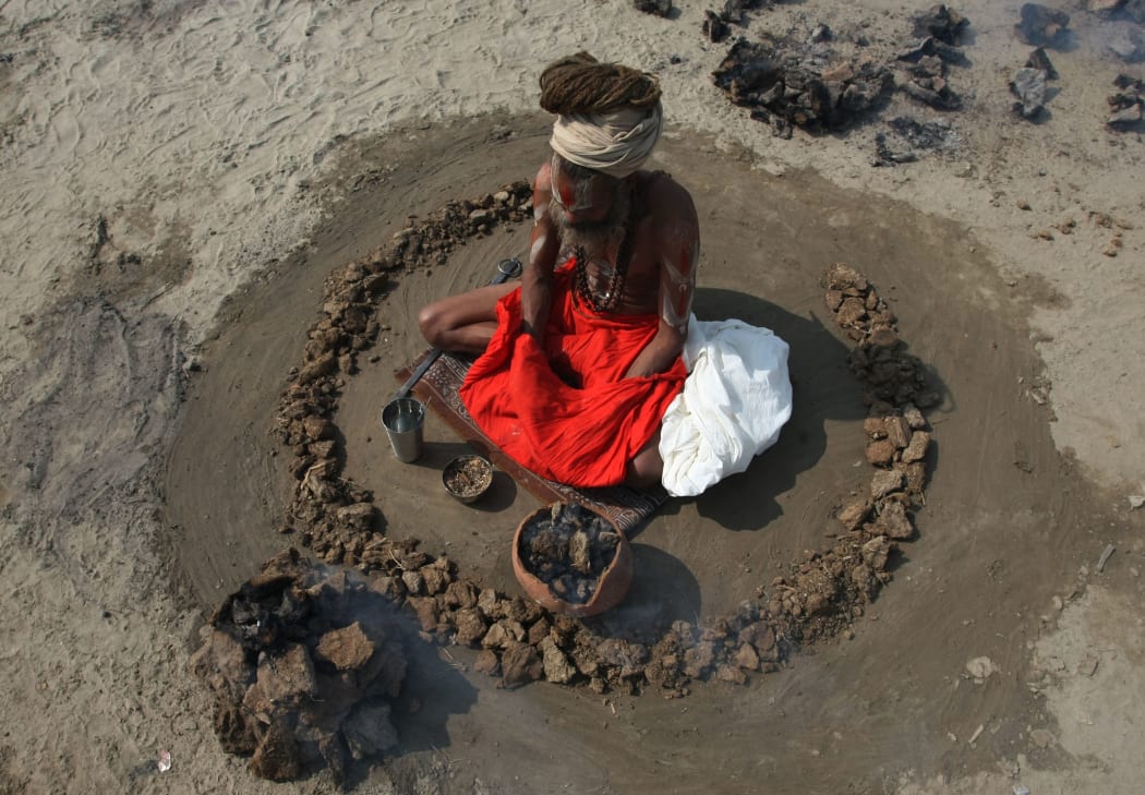 A Hindu devotee burns dried cow dung cakes. (File photo).