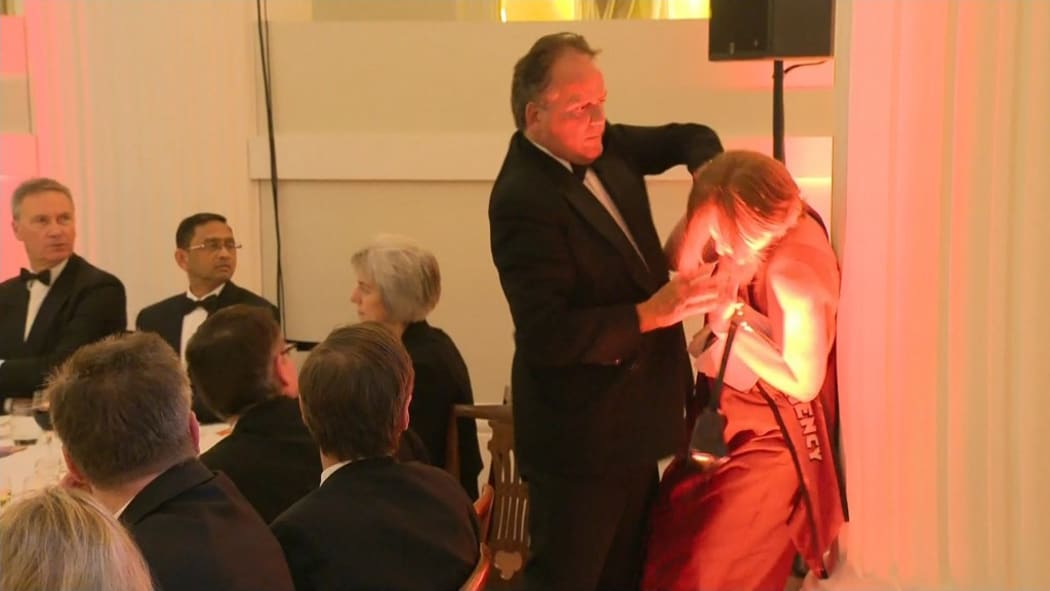 A still image taken from UK Pool video footage on June 21, 2019 shows Conservative MP Mark Field tackling a Greenpeace climate protester at a dinner at Mansion House in the City of London on June 21, 2019.