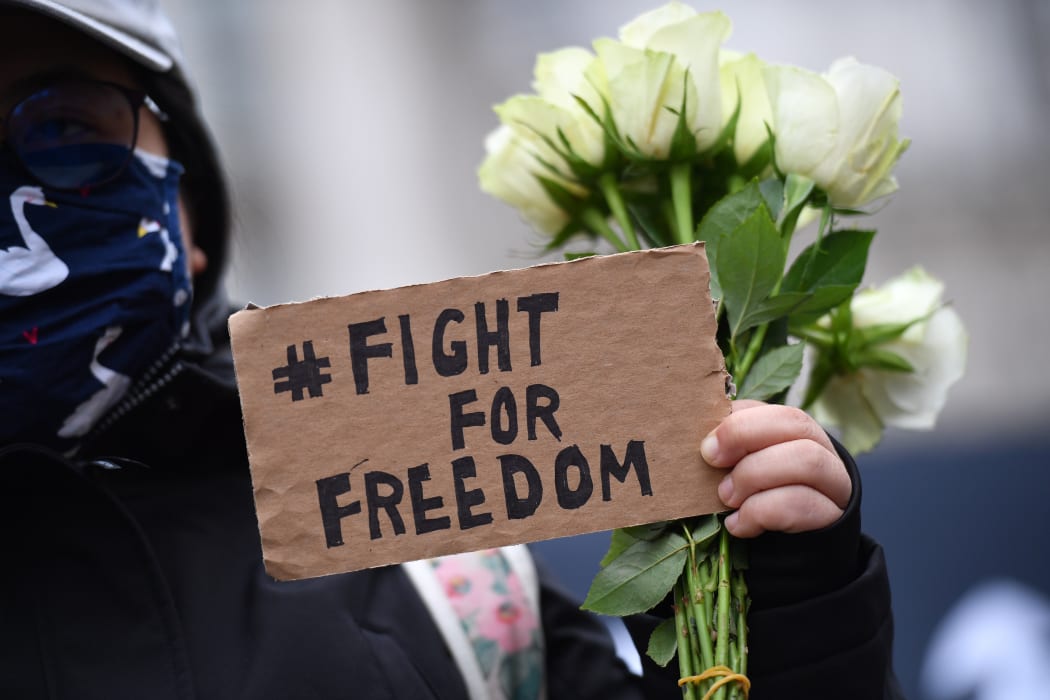 A protester holds a small placard at an event organised by Justitia Hong Kong to mourn the loss of Hong Kong's political freedoms