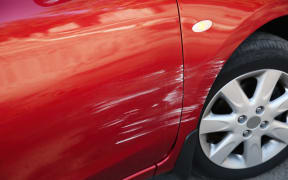 Modern red car with scratch outdoors, closeup