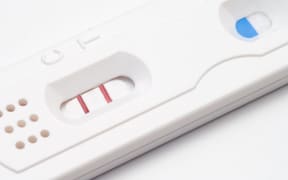 A home pregnancy test showing a positive result. Stock photo