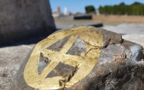 A stone painted with the Scandi wheel symbol, laid to remember Scandinavian settlers buried in Norsewood