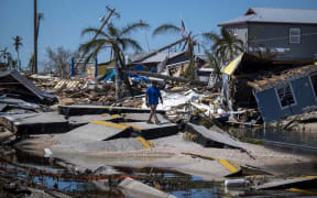 A man walks over a broken section of the Pine Island Road in the aftermath of Hurricane Ian in Matlacha, Florida on October 1, 2022.