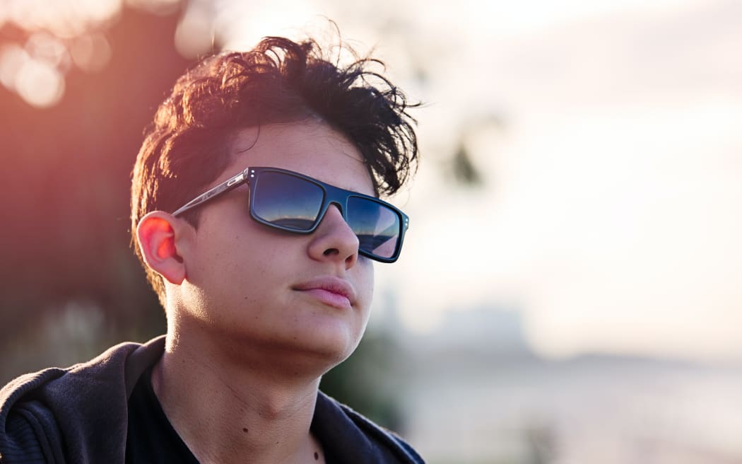 A teenager in the sun wearing sunglasses