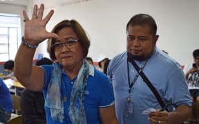 Detained opposition Senator Leila de Lima (L) waves to members of the media as she arrives to vote at a polling precinct in the city of Paranaque in suburban Manila on May 13, 2019. -