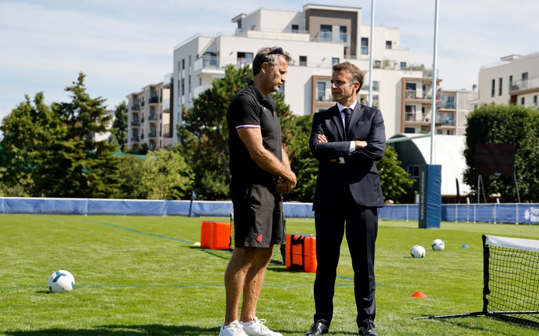 French President Emmanuel Macron speaks with France's head coach Fabien Galthie (L) during a meeting with the team at their base camp's training pitch in Rueil-Malmaison, outside Paris, on September 4, 2023, ahead of the France 2023 Rugby World Cup. (Photo by Ludovic MARIN / POOL / AFP)