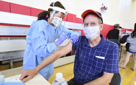 Mike Brady, 66, receives his Covid-19 vaccine from a nurse in California in early January