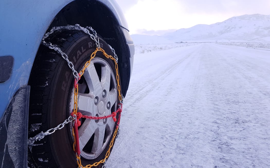 Snow in Tekapo, chains needed on road.