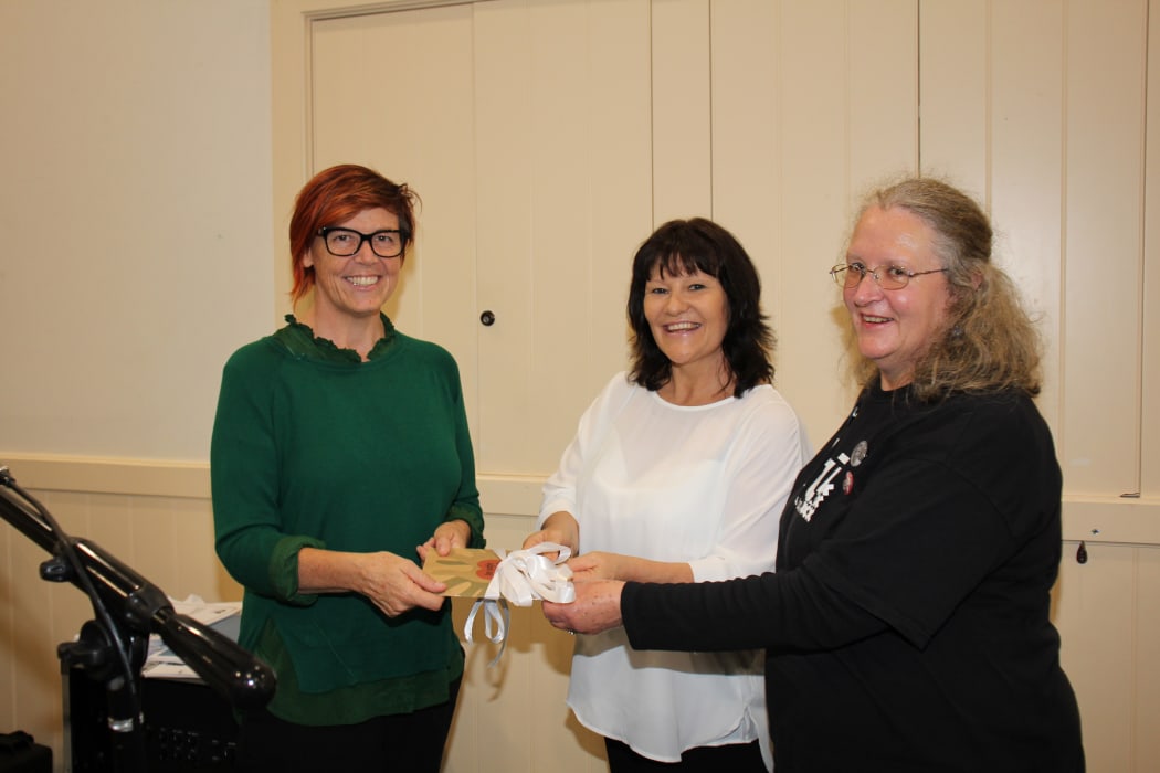 Greens Party senior citizens' spokesperson Jan Logie receiving a copy of the report, In Safe Hands? from Sacha Young (in white) and Marianne Bishop, of the National Aged Care Delegates Committee.