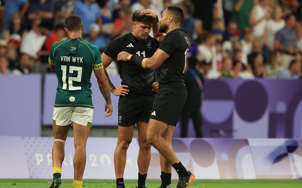 Sione Molia, right, consoles defected All Blacks Sevens team-mate player Moses Leo after their side lost the men's quarter-final match against South Africa at the Paris Olympics.