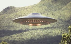UFO (unidentified flying object) above trees, composite image. (Photo by KTSDESIGN/SCIENCE PHOTO LIBRARY / KTS / Science Photo Library via AFP)