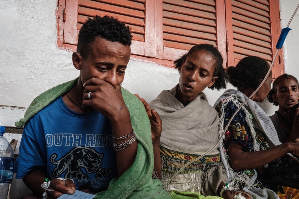 Ataklti Gebremedhin (L), 17, who was injured in his town Togoga in a deadly airstrike on a market, weeps as he recalls his cousin's death