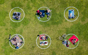 An aerial view shows people gathered inside painted circles on the grass encouraging social distancing at Dolores Park in San Francisco, California on May 22, 2020.