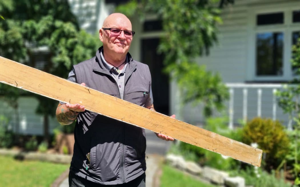 Pete Grennell with the architraving signed by builder Gordon McIsaac in 1913.
