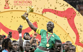 Senegal's forward Sadio Mane holds up the trophy as he celebrates with his teammates after winning the Africa Cup of Nations final against Morocco.