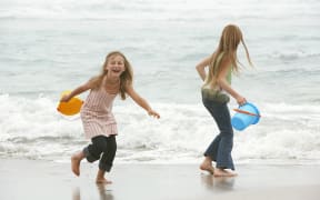 19521586 - two girls playing at the ocean