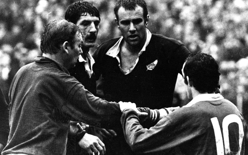 Referee Alan Hosie has ordered Graeme Higginson off. Phil Bennett intervenes. Graham Mourie in middle.