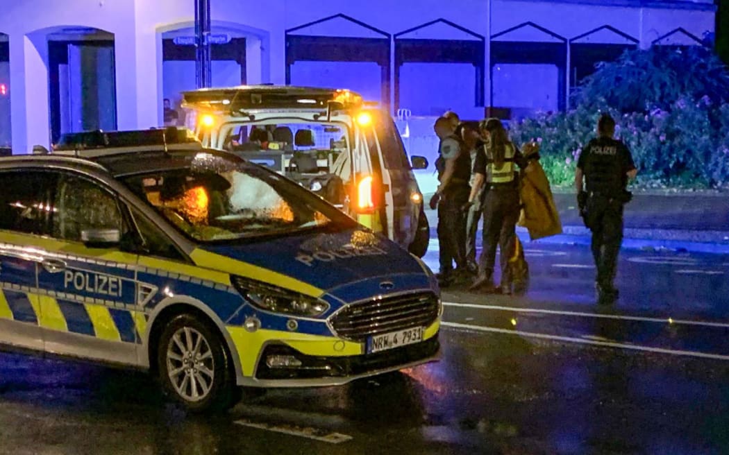 24 August 2024, North Rhine-Westphalia, Solingen: Late in the evening, a man (concealed behind police officers) turns himself in to the police on the street and claims to be the perpetrator. The police have arrested a suspect in connection with the knife attack in Solingen. (Best possible quality) Photo: Christoph Reichwein/dpa (Photo by Christoph Reichwein / DPA / dpa Picture-Alliance via AFP)