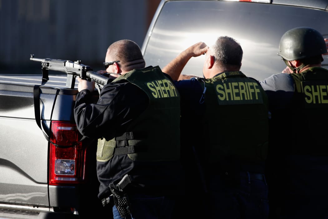 San Bernadino Sheriff officers pursue suspects of the shooting at the Inland Regional Center on 2 December 2015 in San Bernardino, California.