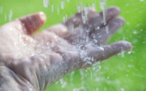 Water splashing on an outstretched hand. (Photo by CRISTINA PEDRAZZINI/SCIENCE PHOT / CPD / Science Photo Library via AFP)