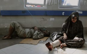 Injured individuals, including children, are being transported to the overwhelmed Al-Shifa Hospital in Gaza City, where doctors face significant challenges in providing care due to its current capacity.