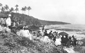 Niue people gathered on the cliffs overlooking Alofi Bay, waiting for a decision on annexation in 1900. Governor Ranfurly was in discussion with Togia and other iki and when a decision was reached a signal was sent to the governor’s vessel, the Mildura, and a ceremony began.