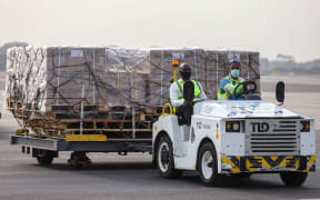 Airport workers transport on dollies a shipment of Covid-19 vaccines from the Covax global Covid-19 vaccination programme, at the Kotoka International Airport in Accra.