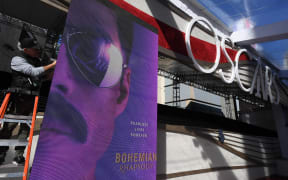 A worker prepares a monitor showing a poster for the film  "Bohemiam Rhapsody" on the red carpet area as preparations for this years Oscars take place in Hollywood, California on February 22, 2019.