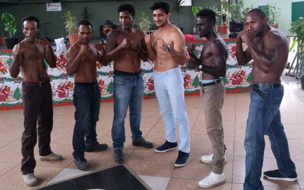 John Korake and Ezatullah Kakar (centre) pose with local boxers on the undercard.